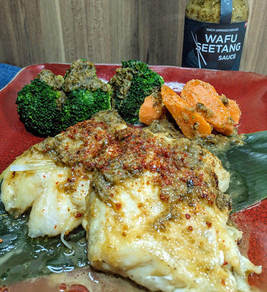 Fisch gedünstet mit Gemüse auf Teller